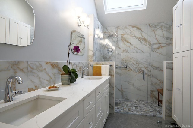 bathroom featuring vanity, a shower with shower door, and vaulted ceiling