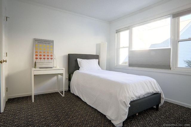 bedroom with crown molding and dark colored carpet