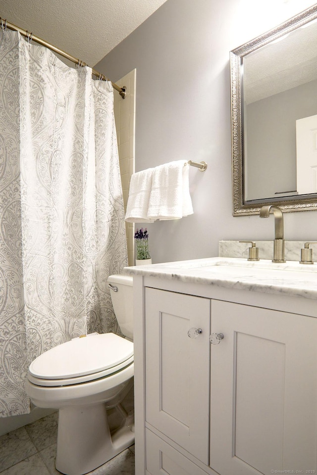 bathroom featuring vanity, tile patterned flooring, a textured ceiling, and toilet