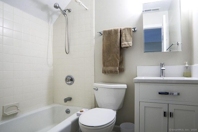 full bathroom featuring tiled shower / bath combo, vanity, and toilet