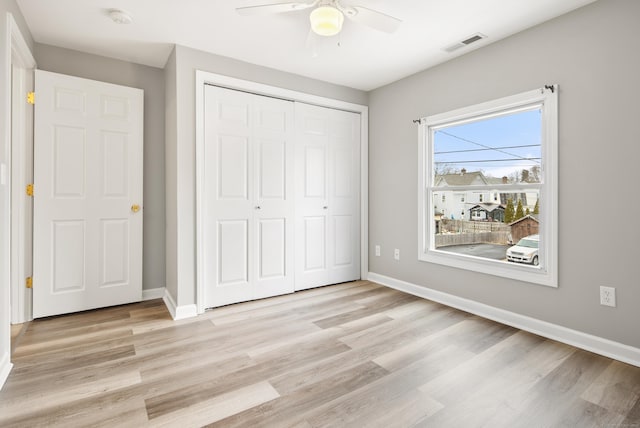 unfurnished bedroom featuring ceiling fan, light hardwood / wood-style flooring, and a closet