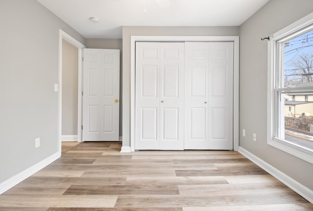 unfurnished bedroom featuring a closet and light wood-type flooring