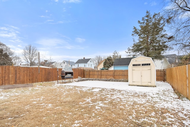 snowy yard with a storage shed