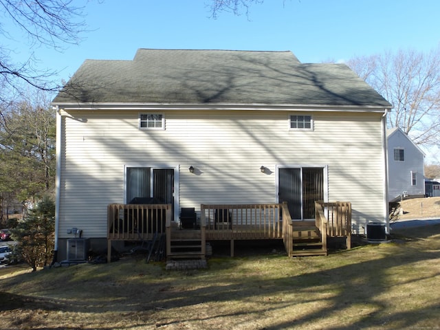 back of house featuring cooling unit, a deck, and a lawn