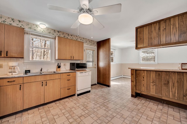 kitchen featuring sink, ceiling fan, dishwasher, and a baseboard heating unit