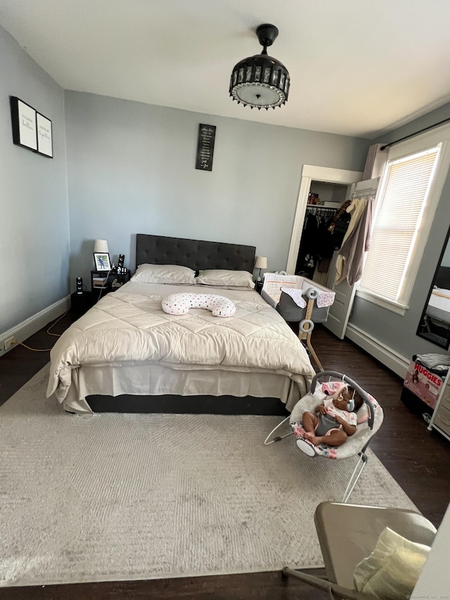 bedroom with dark hardwood / wood-style flooring and a closet