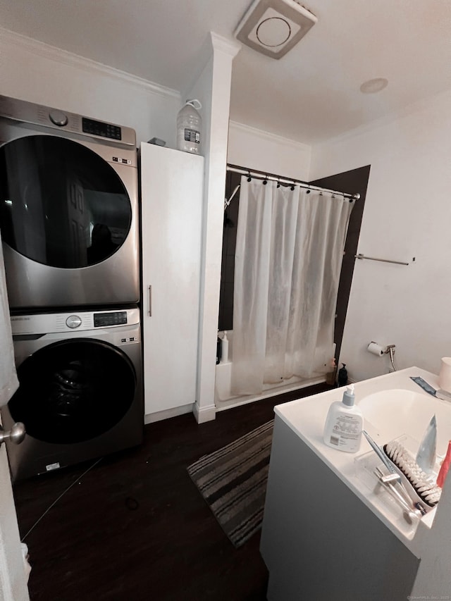 laundry area with stacked washing maching and dryer and ornamental molding