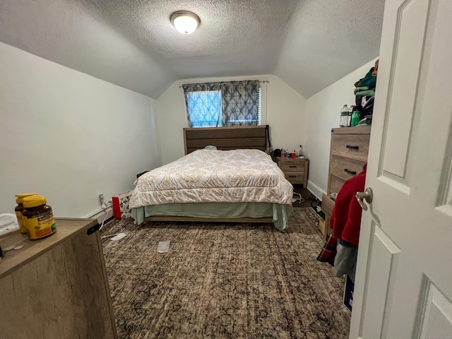 bedroom featuring lofted ceiling and a textured ceiling