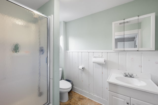 bathroom with vanity, toilet, and a shower with shower door