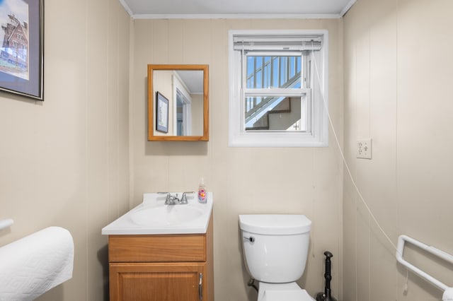 bathroom with vanity, toilet, and wooden walls