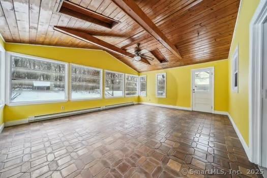 unfurnished sunroom featuring vaulted ceiling with beams, plenty of natural light, baseboard heating, and wood ceiling