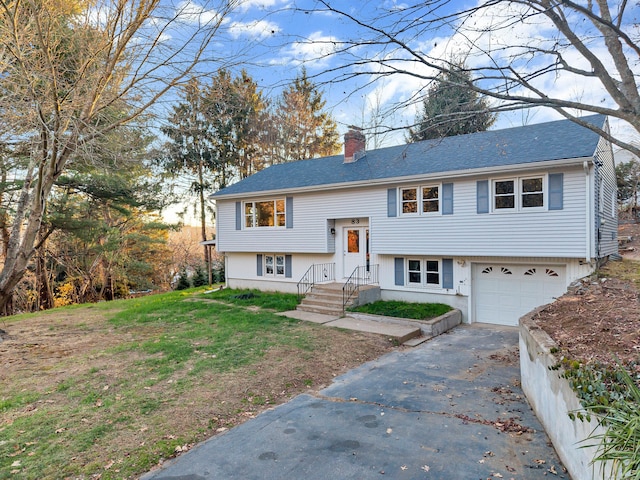 bi-level home with a garage and a front yard