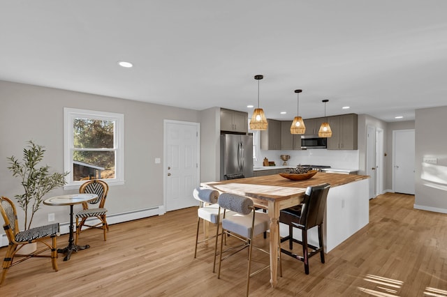 kitchen with decorative light fixtures, light wood-type flooring, stainless steel appliances, and gray cabinets