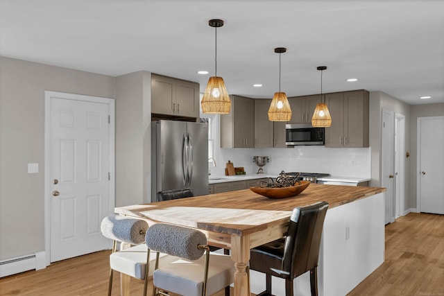 kitchen featuring gray cabinetry, sink, baseboard heating, and appliances with stainless steel finishes