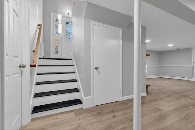 stairway featuring hardwood / wood-style floors and a baseboard radiator