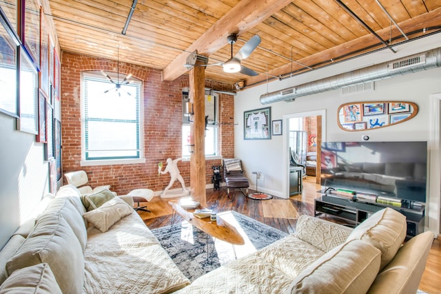 living room featuring brick wall, ceiling fan with notable chandelier, wood-type flooring, beam ceiling, and wooden ceiling