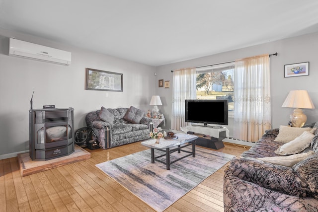 living room featuring a wall mounted AC, light hardwood / wood-style flooring, and a wood stove