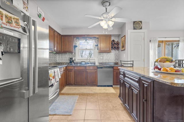 kitchen featuring stainless steel appliances, ceiling fan, light tile patterned flooring, and a wealth of natural light