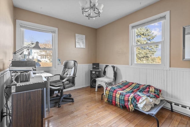 office space with a notable chandelier, light wood-type flooring, and a baseboard radiator