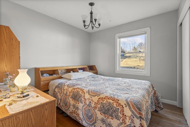 bedroom with a closet, an inviting chandelier, and dark hardwood / wood-style floors