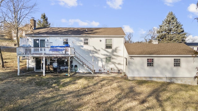 rear view of house featuring a lawn and a wooden deck