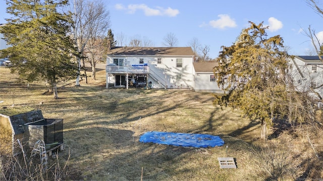 back of property featuring a deck and a lawn