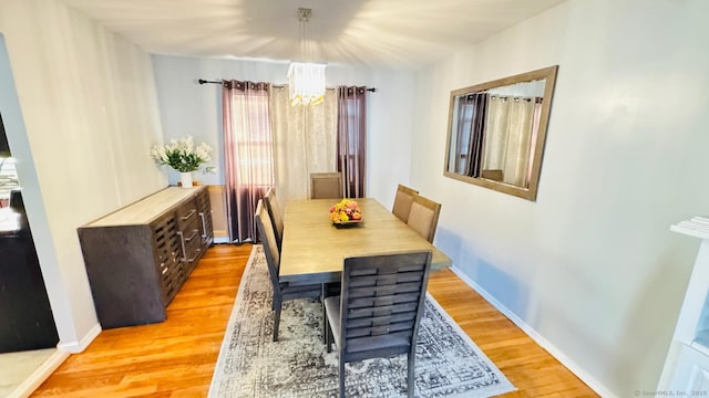 dining area featuring a notable chandelier and light hardwood / wood-style floors