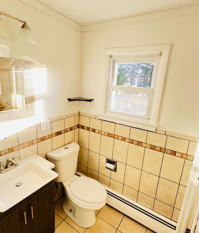 bathroom featuring vanity, baseboard heating, crown molding, tile patterned flooring, and toilet