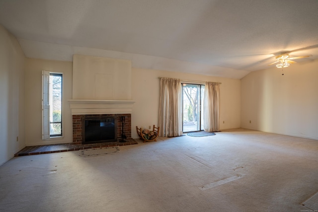 unfurnished living room with carpet, a fireplace, ceiling fan, and vaulted ceiling