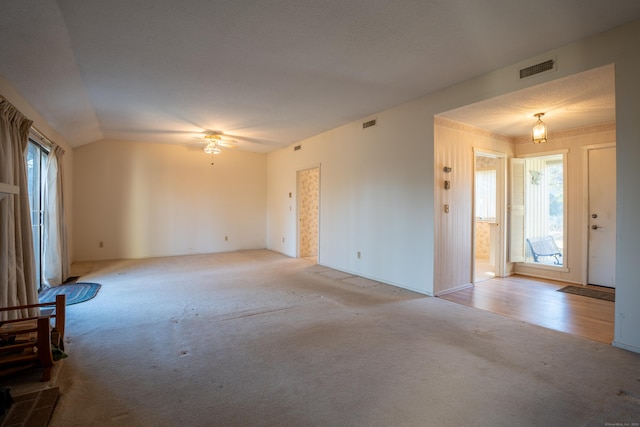 carpeted empty room with ceiling fan and vaulted ceiling