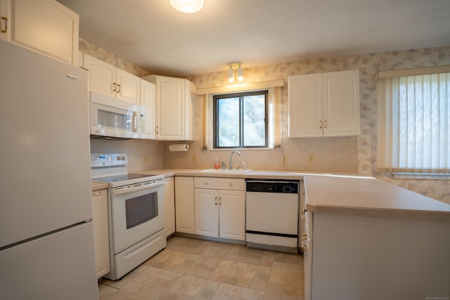 kitchen featuring white appliances, kitchen peninsula, a textured ceiling, white cabinetry, and sink