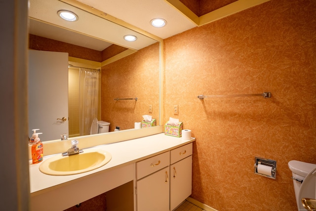 bathroom with toilet, tile patterned floors, and vanity