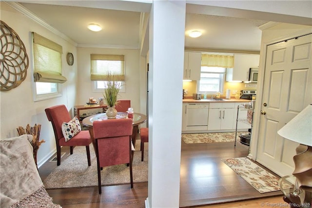 dining space with dark wood-type flooring, sink, and crown molding