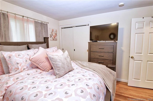 bedroom with light wood-type flooring and a closet