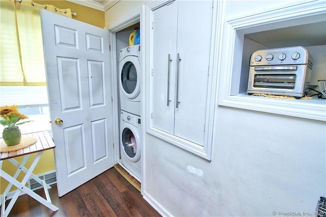 laundry area with ornamental molding, heating unit, stacked washer and clothes dryer, and dark hardwood / wood-style flooring