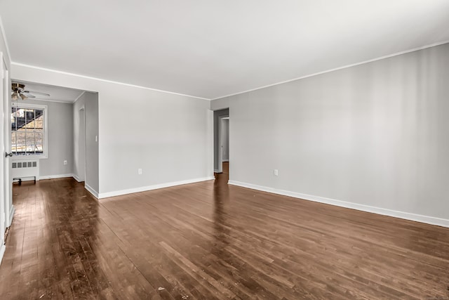 unfurnished room with ceiling fan, dark wood-type flooring, and radiator