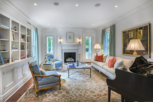 living room featuring a premium fireplace, ornamental molding, built in features, and wood-type flooring