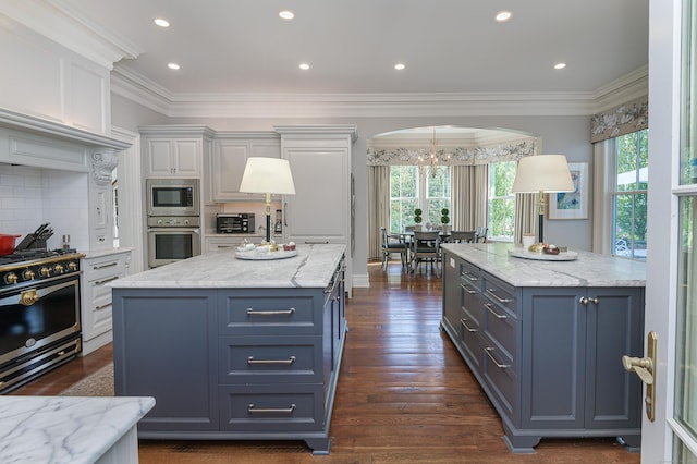 kitchen with stainless steel appliances, tasteful backsplash, dark hardwood / wood-style flooring, a kitchen island, and white cabinets