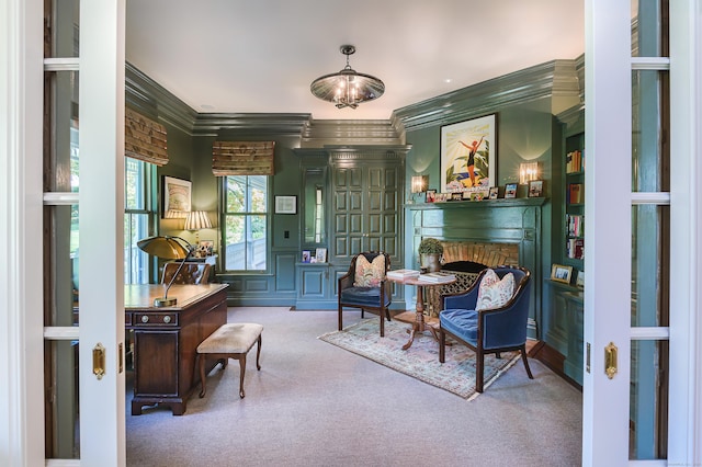 sitting room featuring carpet, crown molding, a notable chandelier, and a fireplace