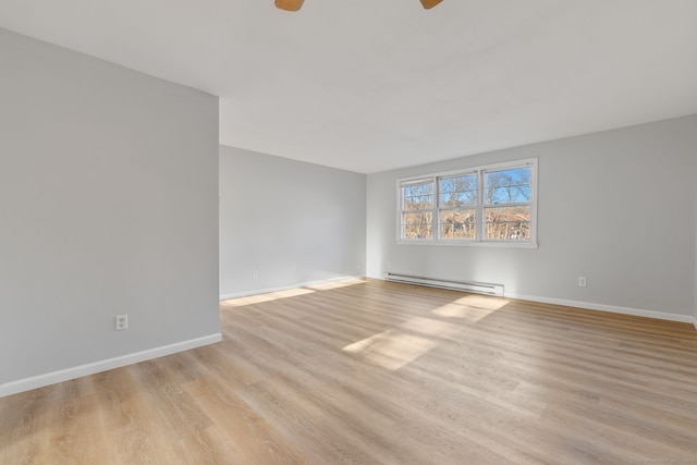 empty room featuring ceiling fan, light hardwood / wood-style floors, and baseboard heating