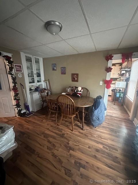 dining area with a paneled ceiling, hardwood / wood-style flooring, and built in features