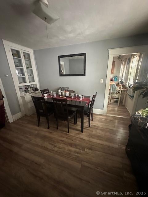 dining space with ceiling fan, dark hardwood / wood-style flooring, and built in shelves