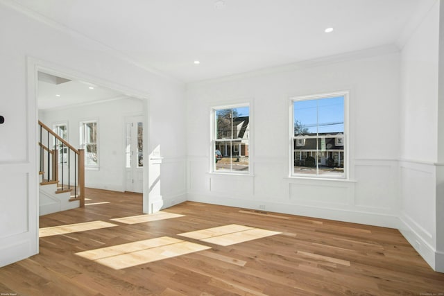 unfurnished room with crown molding, a healthy amount of sunlight, and hardwood / wood-style floors