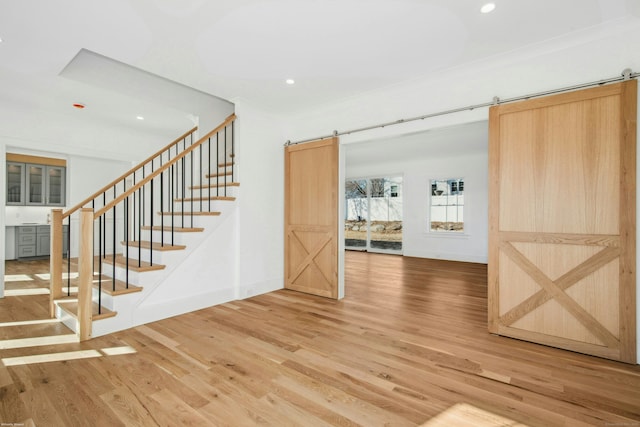 interior space featuring crown molding, hardwood / wood-style flooring, and a barn door