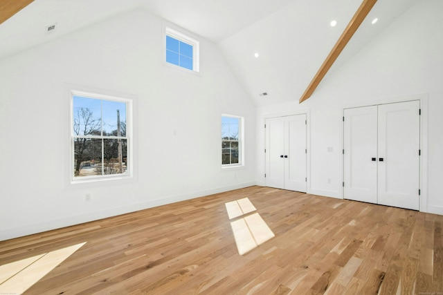 bonus room with high vaulted ceiling and light wood-type flooring