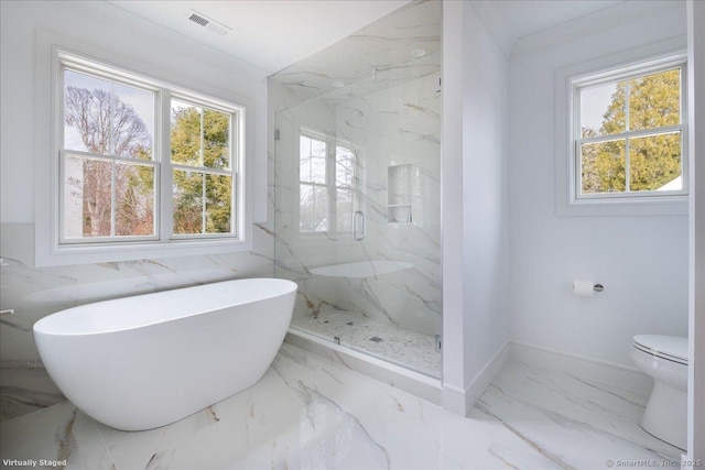 bathroom featuring plenty of natural light, separate shower and tub, and toilet