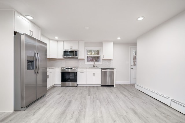 kitchen with a baseboard radiator, white cabinetry, stainless steel appliances, light hardwood / wood-style floors, and sink