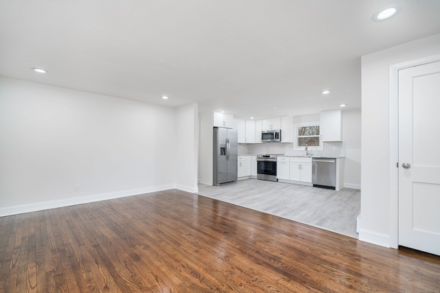 unfurnished living room featuring light hardwood / wood-style flooring and sink