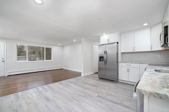 kitchen featuring white cabinets, appliances with stainless steel finishes, and light hardwood / wood-style flooring