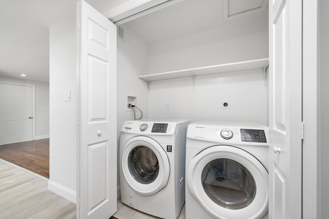 washroom with light hardwood / wood-style floors and washing machine and clothes dryer